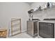 Well-lit laundry room featuring modern washer and dryer units with drying rack, and overhead shelving at 734 Lanarck Way, Peachtree City, GA 30269