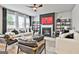 Comfortable living area featuring a modern fireplace, stylish furniture, and large windows, creating a bright and welcoming space at 734 Lanarck Way, Peachtree City, GA 30269