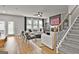 Bright, open-concept living room with modern furnishings, a staircase, and a fireplace, creating a cozy atmosphere at 734 Lanarck Way, Peachtree City, GA 30269