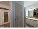 Hallway view of a bathroom with tile floors, white cabinets, tan countertop, and a shower with glass door at 2279 Fieldstone Dr, Conyers, GA 30013