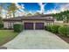Three-car garage with dark wood doors and long driveway lined with manicured hedges and green grass at 2279 Fieldstone Dr, Conyers, GA 30013