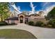 Elegant, light pink stucco home with arched entryway, tall windows, a stone retaining wall, and a curved driveway at 2279 Fieldstone Dr, Conyers, GA 30013