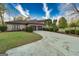 Spacious home with a long, curved driveway leading to a three-car garage surrounded by lush landscaping at 2279 Fieldstone Dr, Conyers, GA 30013
