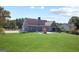 Spacious backyard with lush green grass, mature trees, trampoline, playground, and home exterior at 131 Pecan Lake Dr, Sharpsburg, GA 30277