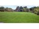 Sprawling green backyard showcasing the home's exterior, mature trees, and ample space for outdoor activities at 131 Pecan Lake Dr, Sharpsburg, GA 30277