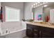 Bathroom with a luxurious soaking tub, dual sink vanity, and a glass block window for privacy at 131 Pecan Lake Dr, Sharpsburg, GA 30277