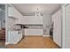 Spacious kitchen featuring white cabinetry, granite counters, stainless steel appliances, and herringbone wood flooring at 131 Pecan Lake Dr, Sharpsburg, GA 30277