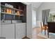 Well-lit laundry room with shelving and modern washer and dryer units next to a dining area with wood floors at 131 Pecan Lake Dr, Sharpsburg, GA 30277