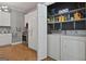 Well-lit laundry room featuring a washer, dryer, and storage shelves at 131 Pecan Lake Dr, Sharpsburg, GA 30277