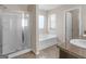 Bright bathroom with a shower stall, soaking tub, and granite countertop at 1064 Lear Dr, Locust Grove, GA 30248