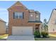 Charming two-story brick home with attached garage, landscaped front yard and inviting curb appeal at 1064 Lear Dr, Locust Grove, GA 30248