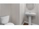 Clean half bathroom featuring a pedestal sink, toilet, and neutral wall color at 1064 Lear Dr, Locust Grove, GA 30248