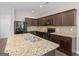 Modern kitchen with granite countertops, dark wood cabinets, and stainless steel appliances at 1064 Lear Dr, Locust Grove, GA 30248