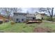 Large backyard featuring a wooden deck, lush green grass, and mature trees providing shade at 4812 White Oak Path, Stone Mountain, GA 30088