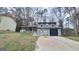 Two-story home featuring a covered porch, attached garage, and a concrete driveway surrounded by mature trees at 4812 White Oak Path, Stone Mountain, GA 30088