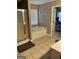 Well-lit bathroom with a shower, soaking tub beneath a window, and access to the main bedroom, blending comfort and style at 2626 Summit Sw Pkwy, Atlanta, GA 30331