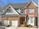 Charming two-story brick home featuring red shutters, a two-car garage, and a well-maintained lawn at 2626 Summit Sw Pkwy, Atlanta, GA 30331