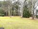 This backyard has a large grass area surrounded by tall trees at 3503 Saddlebrook Dr, Loganville, GA 30052