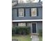 Two-story townhome featuring a gray exterior, black shutters, and a neatly landscaped front entrance at 8547 Jamestown Way, Jonesboro, GA 30238