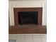 Close-up view of the brick fireplace with a white mantel and a protective screen at 8547 Jamestown Way, Jonesboro, GA 30238