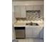 The kitchen features gray cabinets, stainless steel appliances, and a stylish tiled backsplash at 8547 Jamestown Way, Jonesboro, GA 30238