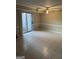 Spacious living room featuring a ceiling fan, tile floors, and sliding glass doors to the backyard at 8547 Jamestown Way, Jonesboro, GA 30238