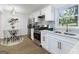 Stylish kitchen with stainless steel appliances, white cabinets, and an adjacent dining area at 1894 Evans Evans Sw Dr, Atlanta, GA 30310