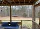 Relaxing screened porch features wicker seating with blue cushions with a view of a spacious, wooded backyard with a trampoline at 383 Kyles Cir # 33, Hiram, GA 30141