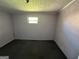 Small bedroom with simple window, neutral walls, and carpeted floor at 45 Poplar St, Porterdale, GA 30014