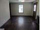 Living room with hardwood floors, neutral green walls, single window, and an exterior door at 5549 Highway 42, Ellenwood, GA 30294