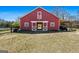 Exterior view of the red barn with large doors, offering a rustic charm to the property at 105 Coogler Way, Brooks, GA 30205