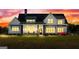 Stunning two-story home illuminated at dusk, showcasing a landscaped yard and inviting front porch at 105 Coogler Way, Brooks, GA 30205