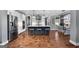 An open kitchen with stainless steel appliances, a central island with barstool seating, and hardwood floors at 105 Coogler Way, Brooks, GA 30205