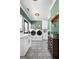 Modern laundry room with patterned tile floor, white cabinetry, and updated appliances at 105 Coogler Way, Brooks, GA 30205