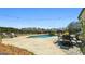 Backyard pool area with a dining set, lounge chairs, and mature trees at 105 Coogler Way, Brooks, GA 30205