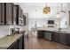 This is a kitchen with stainless steel appliances, granite counters, hardwood floors, and dark cabinets at 243 Summergate Ln, Villa Rica, GA 30180