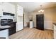 Eat-in kitchen with white cabinets and black appliances, with a view to the dining area at 1343 Burbank Trl, Morrow, GA 30260