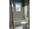 Cozy bathroom featuring a tub and shower combination, tiled walls, and a bright window at 242 12Th St Ne 1 1A, Atlanta, GA 30309