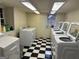 Bright laundry room features black and white tile flooring and multiple washing machines at 242 12Th St Ne 1 1A, Atlanta, GA 30309