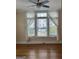 Bright living room features hardwood floors and a large window with sheer curtains at 242 12Th St Ne 1 1A, Atlanta, GA 30309