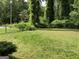 View of the flat, grassy backyard with mature trees at 1288 Lakewood Ne Dr, Conyers, GA 30013