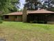 Large backyard featuring a screened porch, chimney and large lawn at 1288 Lakewood Ne Dr, Conyers, GA 30013