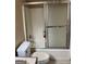 Modest bathroom featuring a shower-tub with sliding glass doors and a standard toilet at 1288 Lakewood Ne Dr, Conyers, GA 30013
