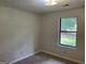 Bedroom with neutral walls, plush carpet, and a large window offering natural light at 1288 Lakewood Ne Dr, Conyers, GA 30013