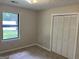 Bedroom featuring neutral walls, plush carpet, a large window, and closet with louvered doors at 1288 Lakewood Ne Dr, Conyers, GA 30013