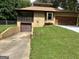 Charming home exterior with a unique design, attached garages, and a well-maintained lawn at 1288 Lakewood Ne Dr, Conyers, GA 30013