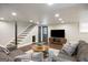 Finished basement features stairs, walkout door, entertainment center and comfortable sofas at 2341 Elmwood Se Cir, Atlanta, GA 30339