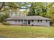 Charming single-story home featuring gray brick, manicured lawn, and inviting front porch at 2341 Elmwood Se Cir, Atlanta, GA 30339