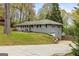 Side view of a gray brick home featuring a long driveway and mature trees, showcasing its setting at 2341 Elmwood Se Cir, Atlanta, GA 30339