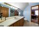 Bathroom featuring a long countertop vanity and walk-in shower; bedroom visible in the background at 680 Milligan Creek Rd, Roopville, GA 30170